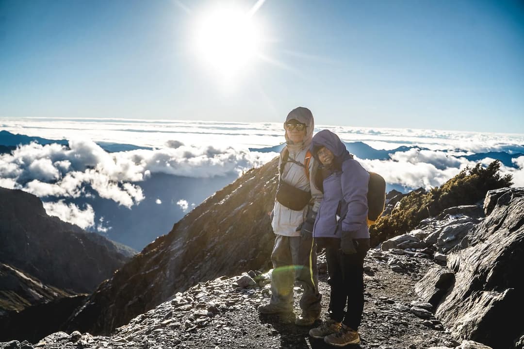 夫妻在玉山主峰稜線上迎著日出與雲海